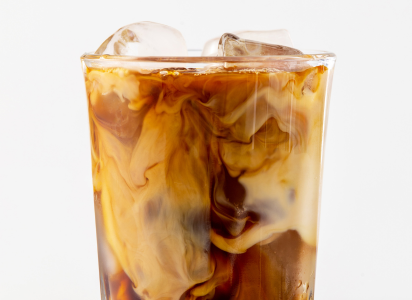 mouth watering glass of iced coffee with creamer